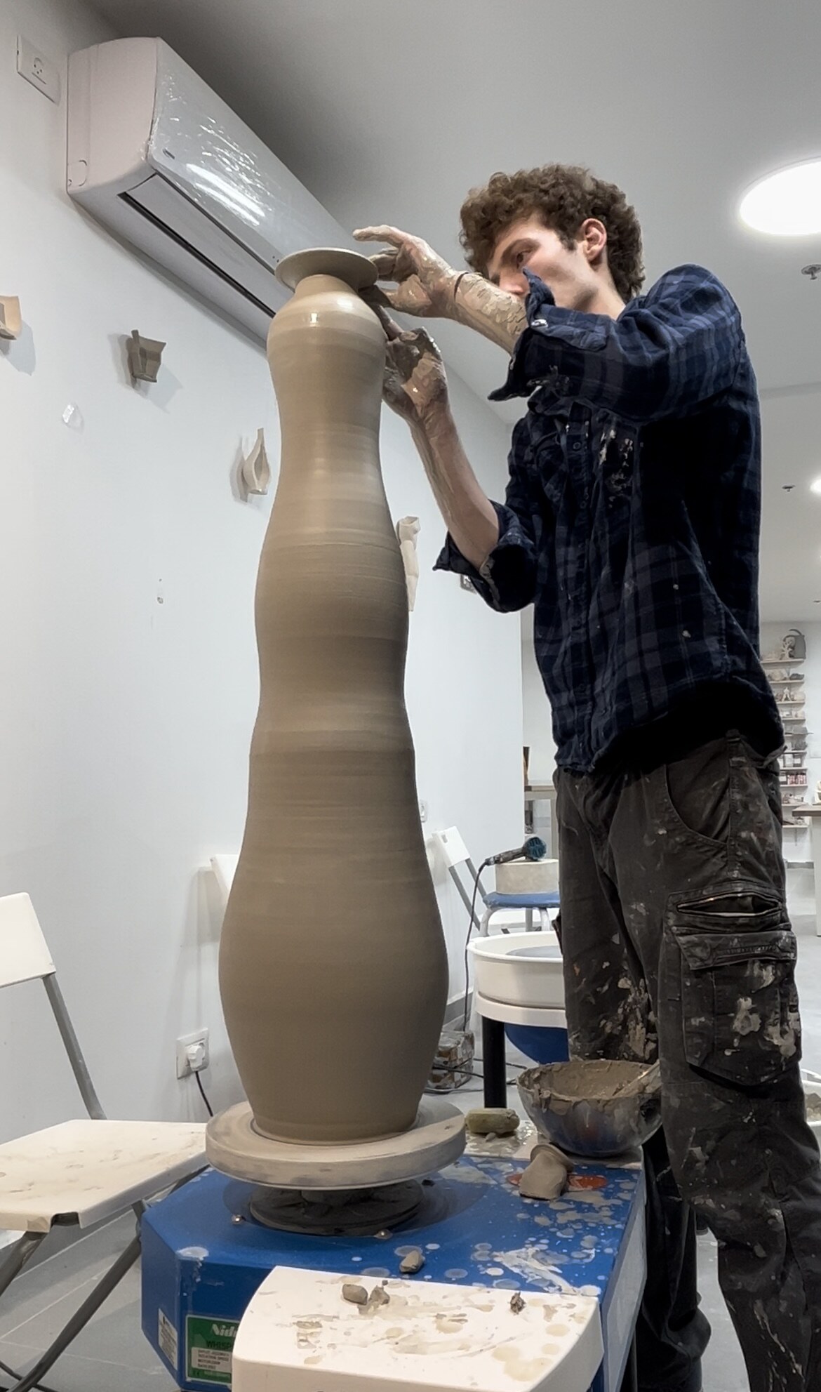 Throwing a tall stoneware form on the wheel